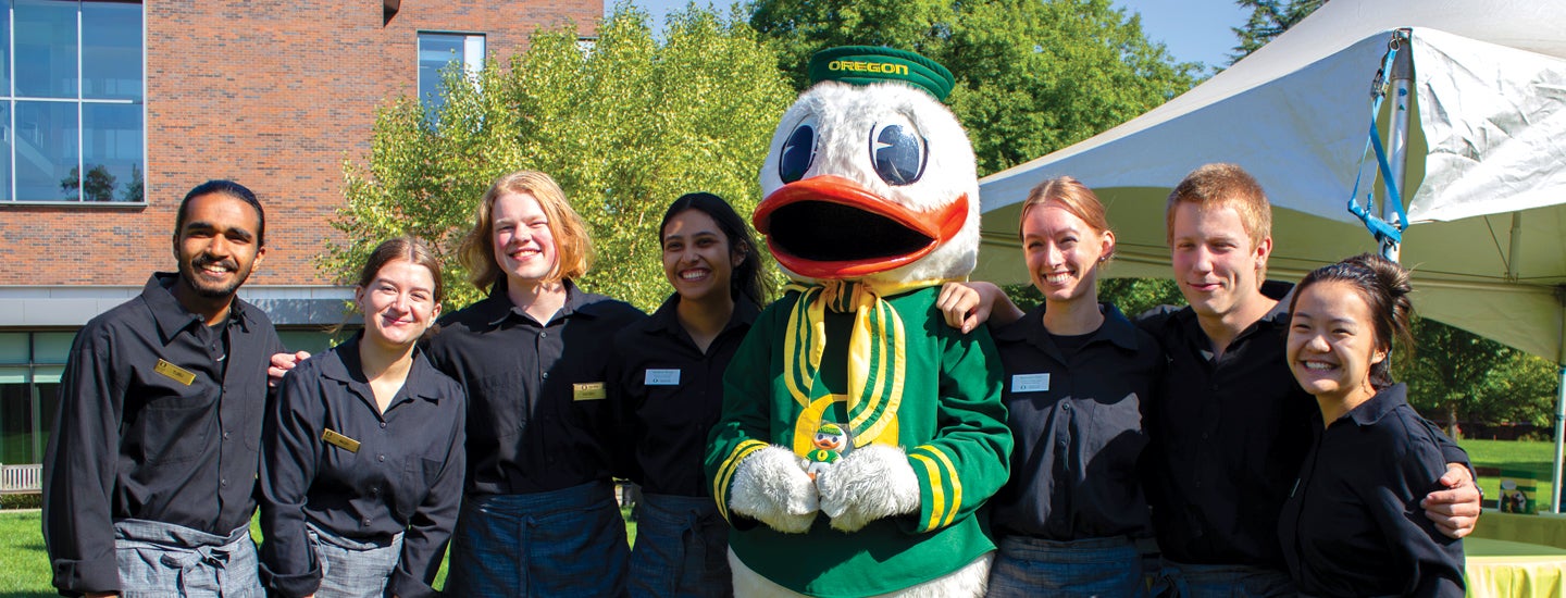 Photo of Oregon Duck mascot with seven catering staff members.