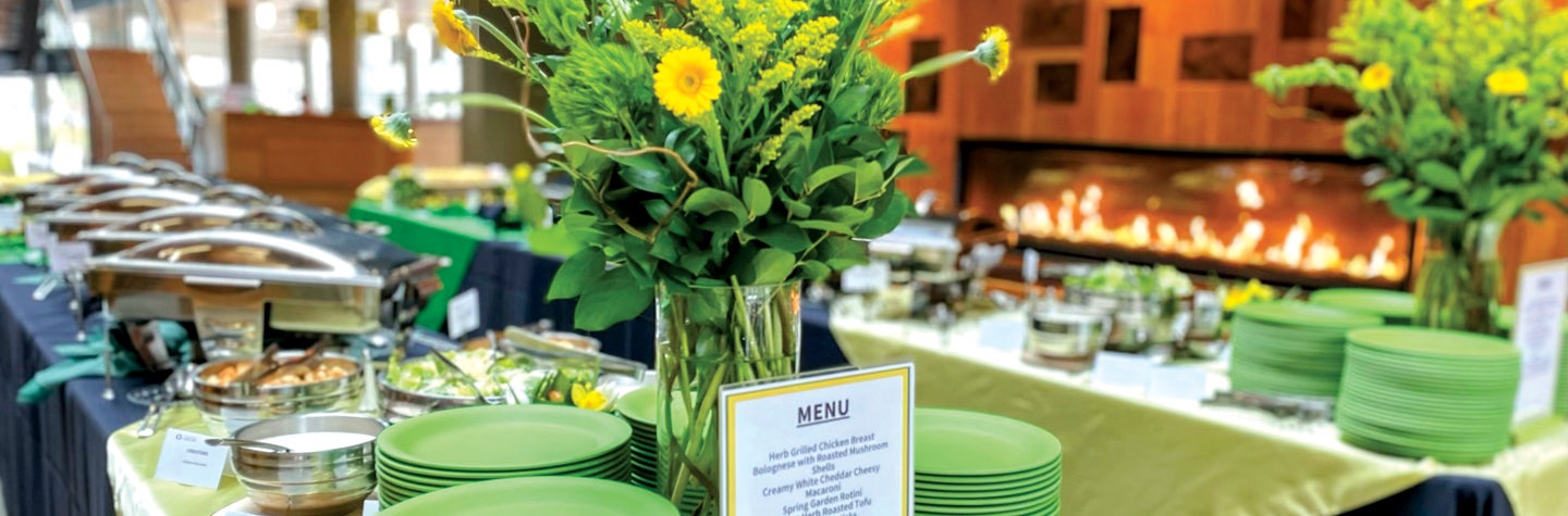 Photo of buffet with flowers and chafing dishes.